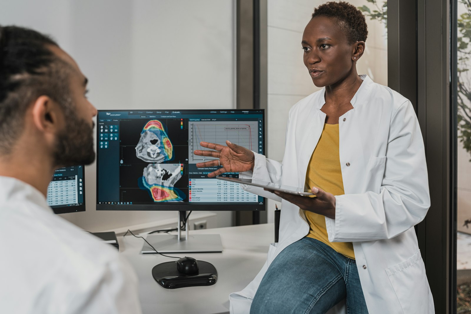 Two clinicians reviewing 3D diagnostic imaging on screen